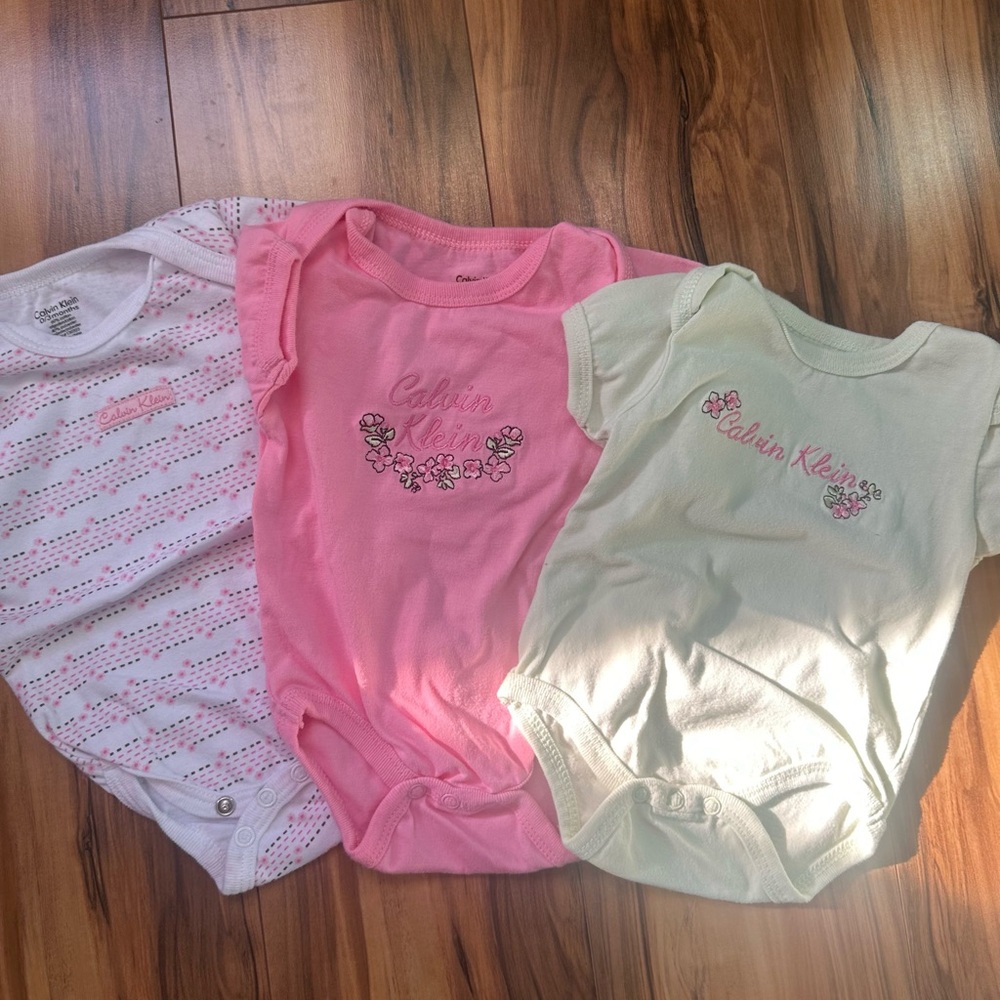 Calvin Klein Pink, White, and Cream Baby Onesies Trio